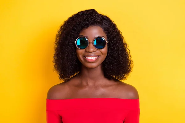 Photo of young beautiful lovely smiling afro girl in sunglasses smiling wear off-shoulders dress isolated on yellow color background — Stock Photo, Image