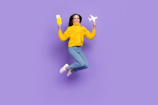 Foto de tamaño completo de la señora saltando mantenga boletos volando en vacaciones de verano desgaste denim aislado sobre fondo de color violeta —  Fotos de Stock