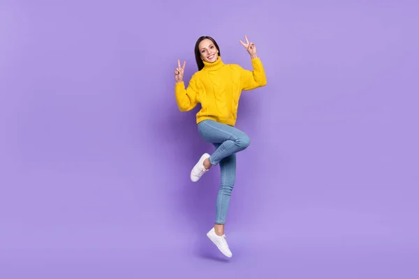 Foto ukuran penuh dari wanita cantik melompat menunjukkan v-sign memakai penarik mustard kasual terisolasi pada latar belakang warna ungu — Stok Foto