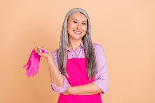 Retrato de atraente mulher de cabelos grisalhos alegre hábil fazendo diariamente limpar isolado sobre fundo cor pastel bege — Fotografia de Stock