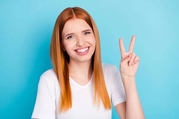 Retrato de adorável alegre senhora sorriso dedos mostrar v-sinal olhar câmera isolada no fundo de cor azul — Fotografia de Stock