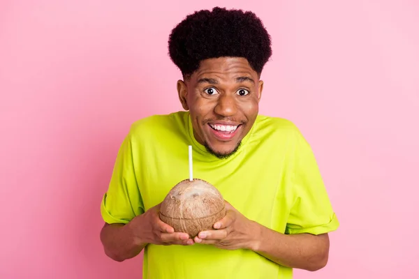 Retrato de chico alegre atractivo bebiendo jugo de coco divirtiéndose aislado sobre fondo de color pastel rosa — Foto de Stock