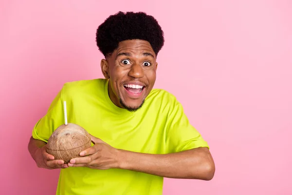 Foto de un encantador joven afroamericano feliz cogido de la mano bebida de coco aislado sobre fondo de color rosa — Foto de Stock