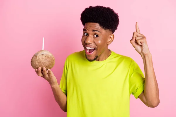 Foto de un joven afro-americano alegre agarrado de la mano idea de bebida de coco aislado sobre fondo de color rosa — Foto de Stock