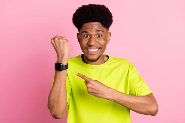Genç mutlu Afro-Amerikalı adamın fotoğrafı. Parmak gösterme, el saati yönetimi pembe renkli arka planda izole edilmiş. — Stok fotoğraf