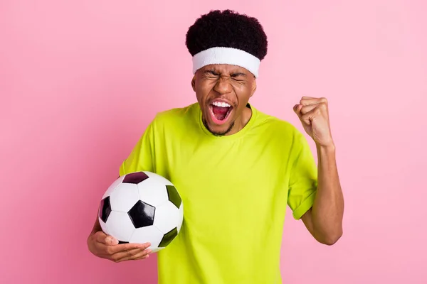 Фото счастливой положительной темной кожи мужчина победитель матча провести футбольный игрок изолирован на розовом фоне — стоковое фото