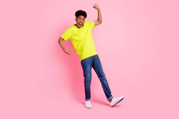 Foto de cuerpo entero del joven afroamericano ganador levantar puños buen humor aislado sobre fondo de color rosa —  Fotos de Stock