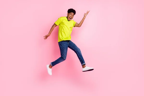 全长侧面照片年轻快乐的非洲小伙子开心的积极的微笑跳起来与粉红色的背景隔离 — 图库照片