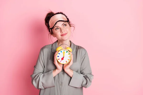 Photo of pretty positive girl arms hold clock look interested empty space isolated on pink color background — Stock Photo, Image
