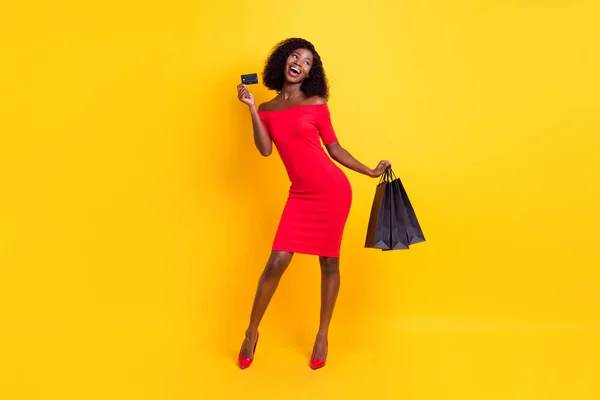 Foto em tamanho completo de jovem bela menina feliz animado após compras mostrar cartão de crédito isolado no fundo de cor amarela — Fotografia de Stock