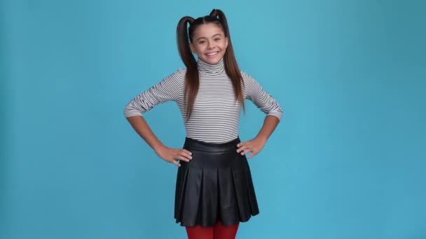 Hezké dítě dívka těšit víkend černé pruhované vzhled izolované modré barvy pozadí — Stock video
