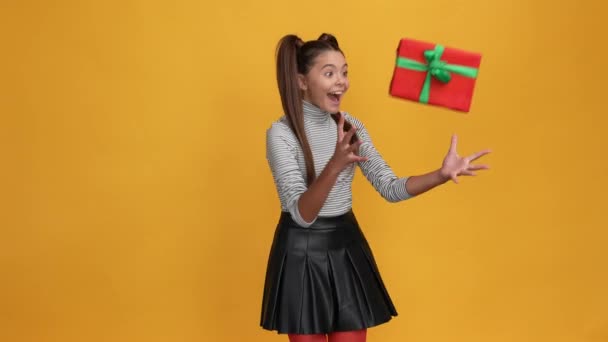 Liten tonåring flicka ta nyår presentbox kram önskad bounty över ljus bakgrund — Stockvideo