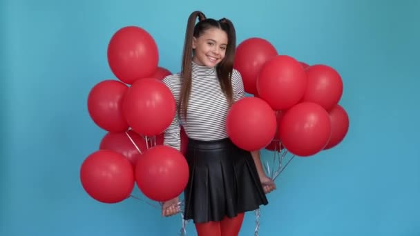 Adorable niño celebrar globos rojos invitado partido aislado color azul fondo — Vídeos de Stock