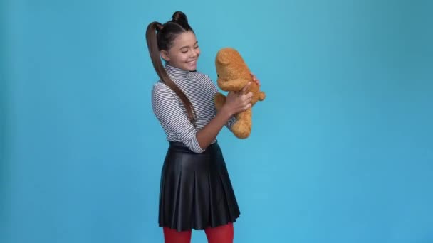 Menina miúdo desfrutar de brinquedo macio aniversário presente isolado azul cor de fundo — Vídeo de Stock