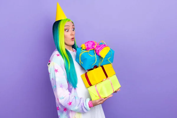 Photo de fou excité dame tenir pile cadeaux omg visage usure cône cap kigurumi costume isolé couleur violette fond — Photo