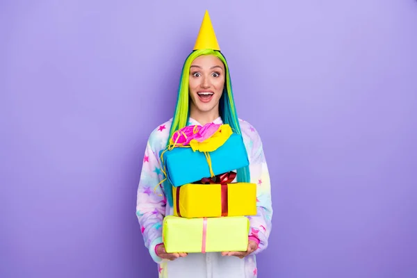 Foto de loca señora emocionada mantenga pila caja de regalo boca abierta use tapa de cono traje kigurumi aislado color púrpura fondo —  Fotos de Stock