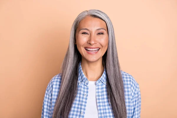 Fénykép elég aranyos nyugdíjas nő viselni kockás ing mosolygós elszigetelt bézs színű háttér — Stock Fotó