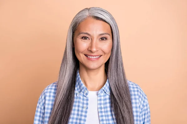 Fénykép fényes bájos hölgy nyugdíjas öltözött kockás ing mosolygós elszigetelt bézs színű háttér — Stock Fotó