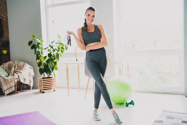 Foto de menina jovem magro forte vestido terno esporte segurando pulando corda sorrindo dentro de casa casa — Fotografia de Stock