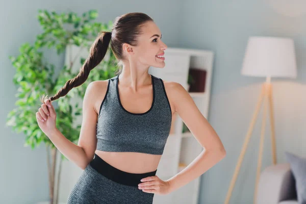 Foto de señora de ensueño fresco usar traje deportivo sonriente mano brazo cola de caballo en el interior casa —  Fotos de Stock