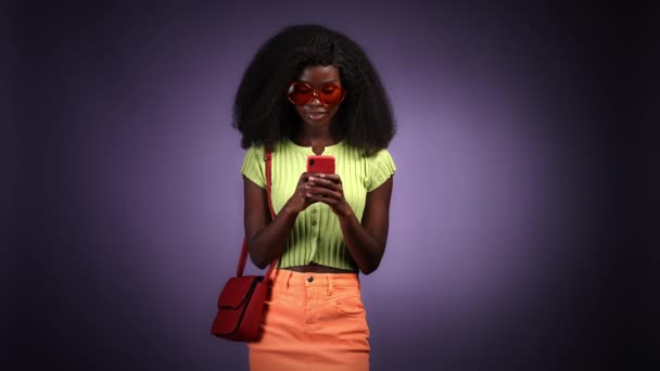 ミレニアル世代の女性のコメントアプリデバイスは、隔離された暗い色の背景をテキストメッセージ — ストック動画