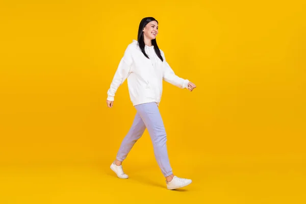 フルサイズの写真の女性は遊歩道散歩を満たしている友人は輝き黄色の背景に隔離されたプルオーバージャンパーを着用 — ストック写真