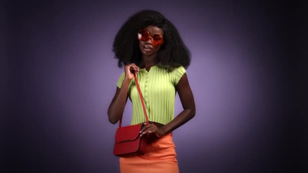 Güzel bayan el çantası, ucuz kıyafetler koyu renkli arka plan. — Stok video