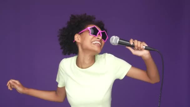 Excitada senhora cantar microfone hip hop dança isolado cor roxa fundo — Vídeo de Stock