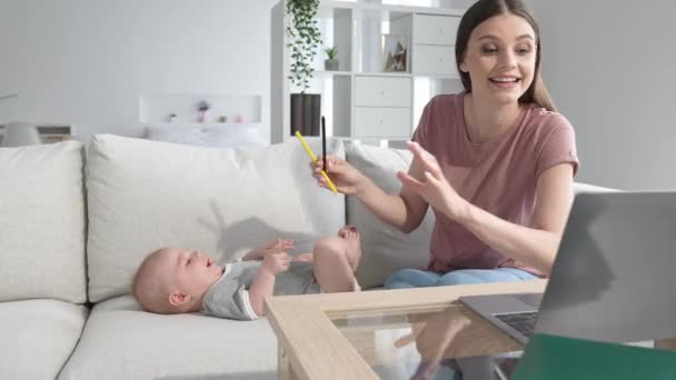 Umtriebige Mutter hat kein Kindermädchen spielen Baby arbeiten zu Hause Netbook-Typ E-Mail — Stockvideo