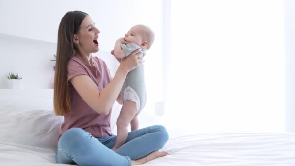 Carino dolce babysitter lancio bambino bambino ridendo al chiuso stanza — Video Stock