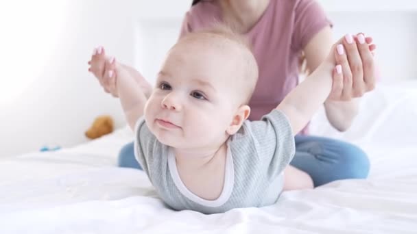Terapeuta señora estiramiento bebé brazos jugar volar alas obstetricia interior — Vídeos de Stock