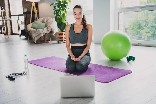 Ritratto di attraente allegra ragazza sottile seduta su tappeto facendo yoga posa posizione guardando sul web cam blog a casa al chiuso — Foto Stock