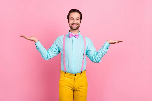 Foto de cara jovem bonito funky vestida roupas teal comparar braços espaço vazio sorrindo isolado cor de fundo rosa — Fotografia de Stock