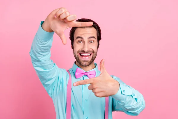Foto de divertido encantador joven usar traje de color turquesa sonriendo mostrando los dedos foto tiro aislado color rosa fondo — Foto de Stock