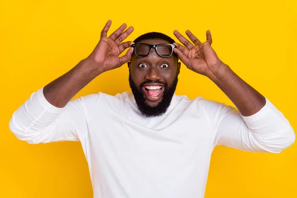 Photo of astonished positive man hands touch eyeglasses open mouth isolated on yellow color background — Stock Photo, Image