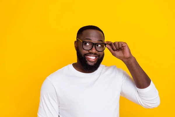 Photo de l'homme créatif positif bras tactile lunettes rayonnant sourire regarder espace vide isolé sur fond de couleur jaune — Photo