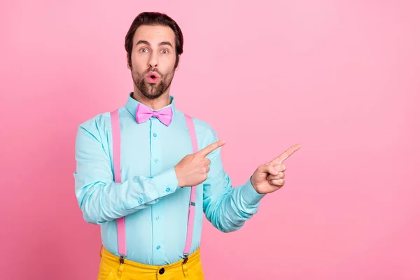 Foto von schockierten funky junge Kerl gekleidet Krickenkleidung zeigt zwei Finger leeren Raum große Augen isoliert rosa Farbe Hintergrund — Stockfoto