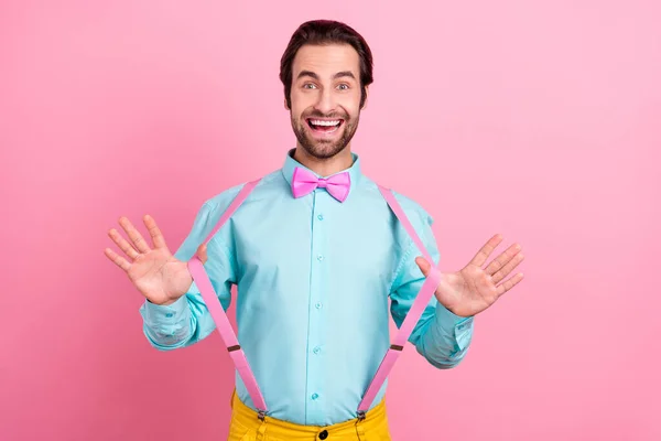 Foto de impressionado funky jovem vestido roupas teal ajustando suspensórios sorrindo isolado cor-de-rosa fundo — Fotografia de Stock