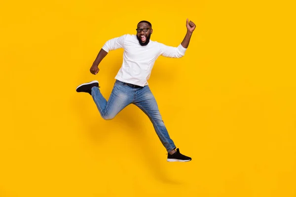 Foto de corpo inteiro do cara esportivo surpreso animado divirta-se alegrar tempo livre isolado no fundo de cor amarela — Fotografia de Stock