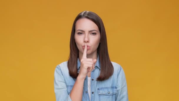 Lady zet vinger mond niet zeggen geïsoleerde bruine mosterd kleur achtergrond — Stockvideo