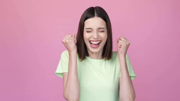 Ecstatic lady celebrate lucky jackpot fsts up isolated pink color background — стоковое видео