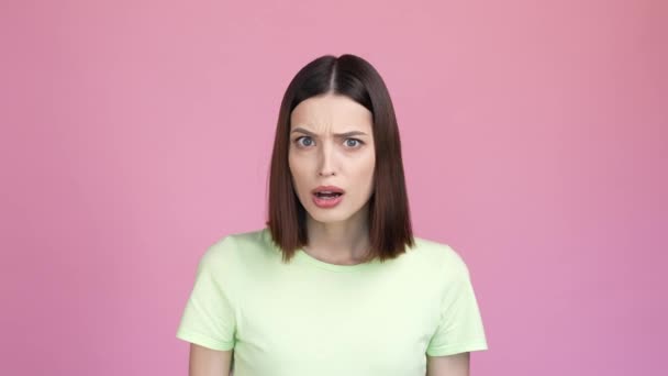 Förbluffad dam fruktansvärd nyhet besviken isolerad rosa färg bakgrund — Stockvideo