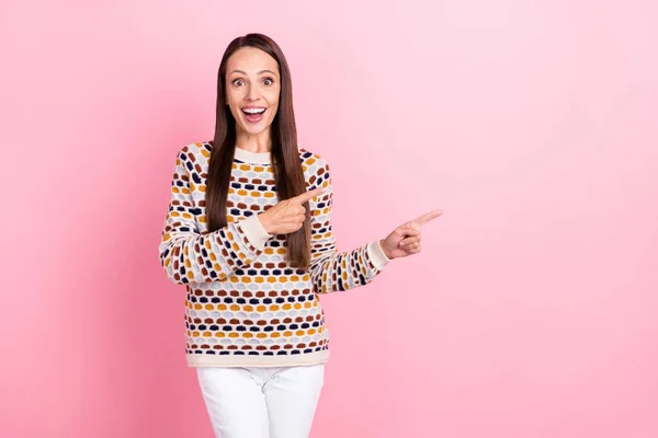 Foto di carino impressionato maturo signora vestito pullover stampa puntando due dita spazio vuoto sorridente isolato colore rosa sfondo — Foto Stock