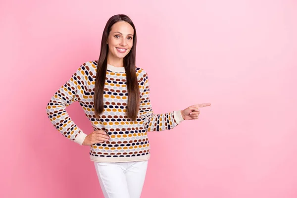 Foto di dolce bella giovane donna indossare maglione punteggiato sorridente dita puntando spazio vuoto isolato colore rosa sfondo — Foto Stock