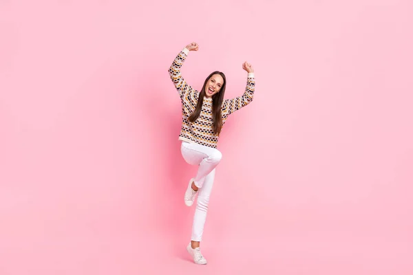 Foto de linda mujer joven afortunada usar suéter punteado sonriendo caminando puños ascendentes aislado color rosa fondo — Foto de Stock