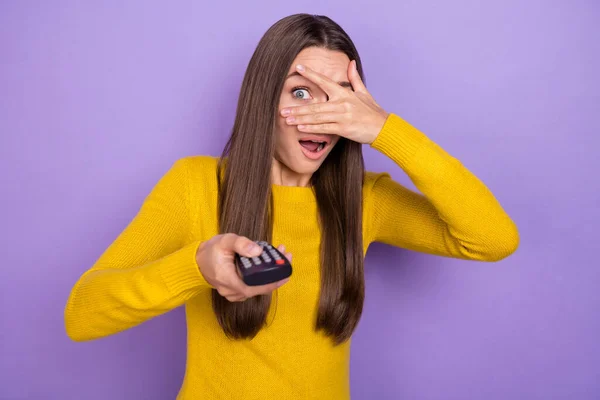 Photo of young pretty woman scared cover eyes hand watch horror movie isolated over purple color background — Stock Photo, Image