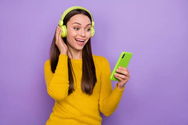 Foto de niña alegre joven uso móvil escuchar radio melodía mp3 repost aplicación aislada sobre fondo de color púrpura — Foto de Stock