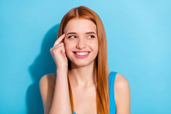 Foto de doce brilhante jovem mulher usar top singlet sorrindo dedo templo olhando espaço vazio isolado azul cor fundo — Fotografia de Stock