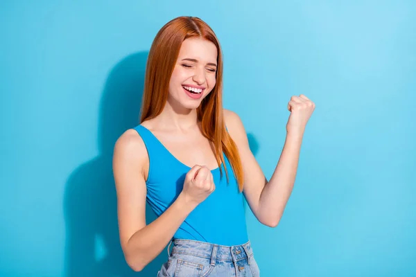 Foto portrét červená vlasy žena se směje gestikulace jako vítěz usmívá izolované pastelově modré barvy pozadí — Stock fotografie