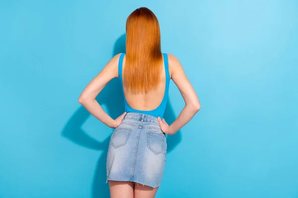 Indietro posteriore dietro vista ritratto di bella ragazza attraente posa mani figura sottile sui fianchi isolato su vibrante sfondo di colore blu — Foto Stock